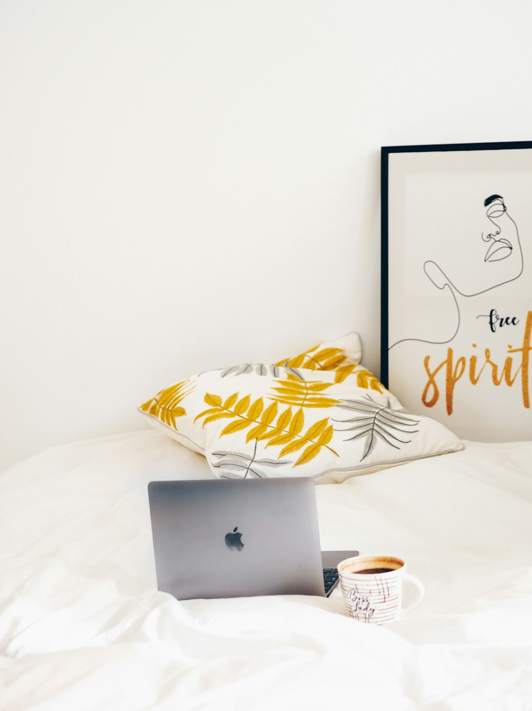 Laptop, notebook and coffee on a wooden desk by a window